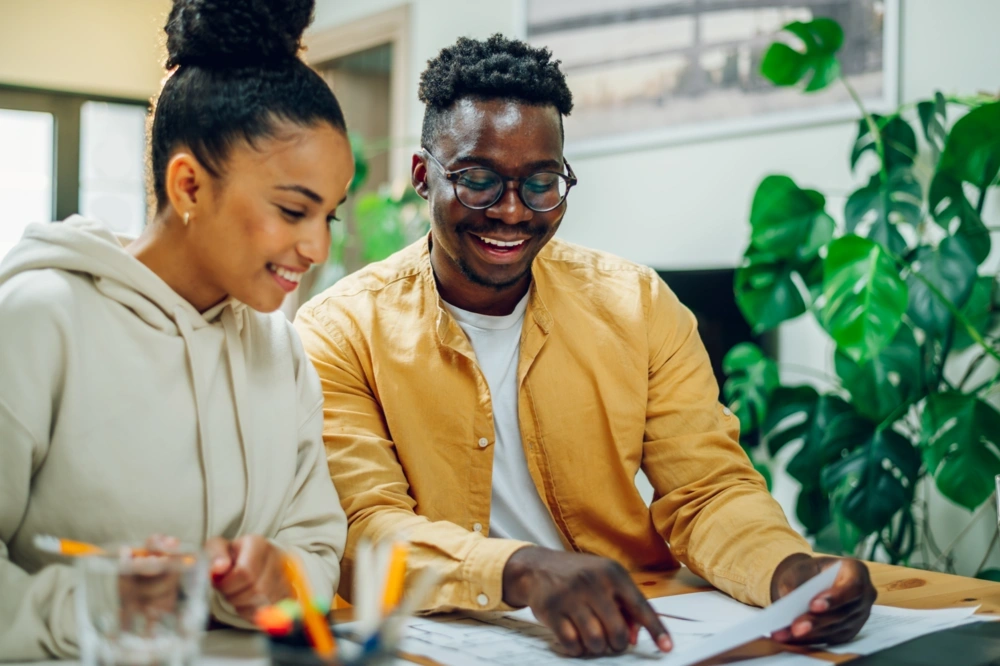 Two people looking over a sheet of paper